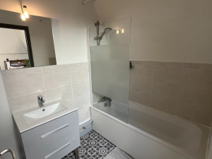 Photo de galerie - Rénovation de la salle de bain avec changement du carrelage mural - robinetterie de l'évier et de la baignoire - installation de la paroi de baignoire