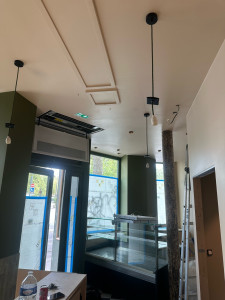 Photo de galerie - Réalisation de travaux électriques dans un local professionnel : pose et raccordement de plusieurs luminaires suspendus, installation d’éclairage au plafond et finitions électriques. Travail propre et soigné, avec respect de l’esthétique du local.