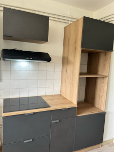 Photo de galerie - Montage et réglage des caissons de cuisine, préparation du plan de travail, installation et intégration de la plaque de cuisson, puis pose et raccordement de la hotte avec finitions propres et conformes aux normes