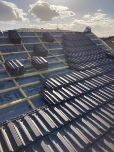 Photo de galerie - Travaux de pose de tuiles en cours, réalisés avec précision et selon les normes pour une toiture résistante et durable.”