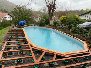Photo de galerie - Montage piscine bois avec lambourdes iroko et lames de terrasse en bois exotique Merbau 