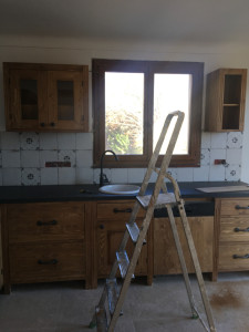 Photo de galerie - Pose d'une cuisine en bois massif avec installation d'une plaque de cuisson , évier , hotte aspirante . 