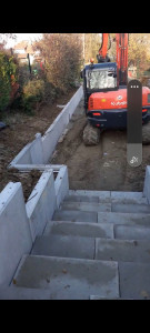 Photo de galerie - Pose les murs en L et des escaliers pré-fabriquer avec pelleteuse 