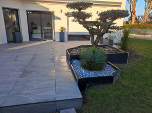 Photo de galerie - Réalisation terrasse béton recouvert d'un dallage sur plots, jardinier en palis d'ardoise et bois exotic, 