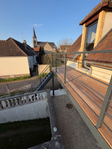 Photo de galerie - Réalisation d’un accès extérieur par un escalier avec marche caillebotis donnant sur une terrasse en bois exotique le tour réalisé sur une structure métallique.