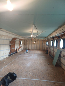 Photo de galerie - Pose de plaques de plâtre à bord d’une péniche.