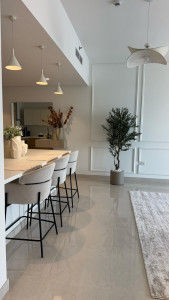 Photo de galerie - Espace moderne et lumineux avec moulures murales, cuisine ouverte et matériaux élégants.
Un rendu épuré et haut de gamme qui apporte une ambiance chaleureuse et raffinée.