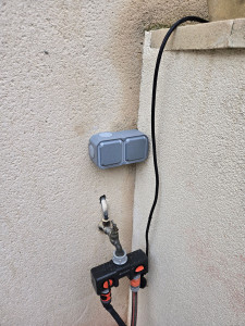 Photo de galerie - Pose d’une double prise etanche en extérieur dans un jardin.