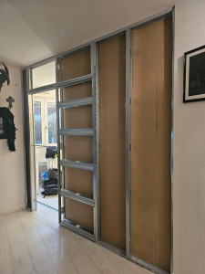 Photo de galerie - Construction murale avec plaque de plâtre et porte coulissante.