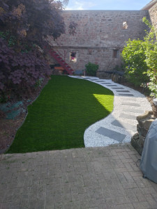 Photo de galerie - Création d'une allée en ardoises avec du gravier ice blue et pose de gazon synthétique 