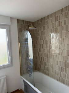 Photo de galerie - Installation d’une paroi de douche avec ajustement, fixation et raccordement de la robinetterie.