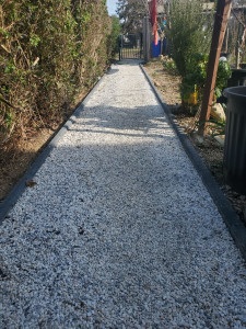 Photo de galerie - Réalisation d'un chemin piétonnier avec bordure et gravillons.