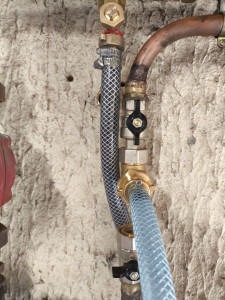 Photo de galerie - Réalisation du desembouage du circuit chauffage.
à droite : l'eau propre injectée dans le retour du circuit chauffage, pour décoller les boues .
à gauche : l'eau du circuit chauffage expulsé du réseau. 