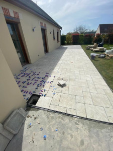 Photo de galerie - Terrasse en carrelage imitation pierre avec pose en opus, offrant un rendu naturel, élégant et durable.
