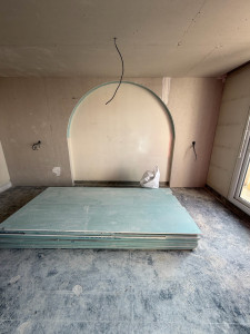 Photo de galerie - Création d’une ouverture cintrée en plaques de plâtre avec réalisation sur mesure des formes arrondies. Travaux de plâtrerie et d’aménagement intérieur alliant précision, esthétique et finitions de qualité.