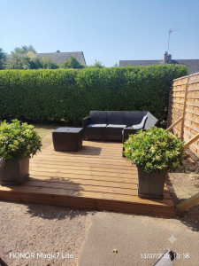 Photo de galerie - Réalisation d'une terrasse en bois sur mesure, alliant esthétique et confort pour vos espaces extérieurs. Un aménagement soigné pour profiter pleinement de votre jardin par notre Artisan.