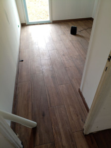 Photo de galerie - Pose d'un carellage de 23 x 120 sur natte de désolidarisation fini avec joint couleur chocolat et ces plinthes