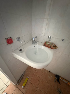 Photo de galerie - Installation et raccordement d’un lavabo : pose de la robinetterie, raccordements d’alimentation en eau et évacuation.