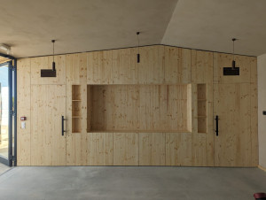 Photo de galerie - Habillage d'un panneau de mur intégrant des rangements et portes