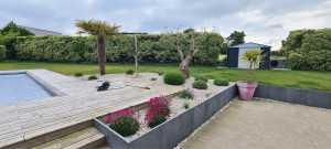 Photo de galerie - Réalisation d’un aménagement autour d’une piscine, terrasse bois, pose de palissades d’ardoise, chaînette pavé, plantation d’un olivier et de diverses plantations
