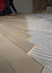 Photo de galerie - Pose de parquet avec finitions soignées.