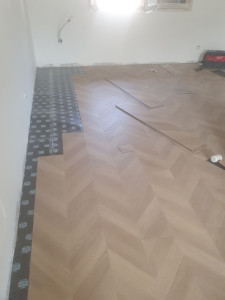 Photo de galerie - Pose de lames PVC imitation bois en motif chevrons. Travail réalisé avec soin et précision pour une finition propre et esthétique.