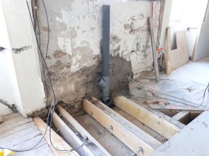 Photo de galerie - Decaissage mur en pierre pour raccordement évacuation PVC/colonne en fonte
