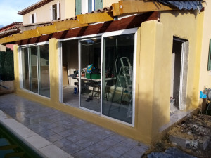 Photo de galerie - Réalisation véranda, toiture, mur, placo, isolation et pose fenêtres et baies vitré. 