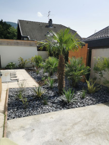 Photo de galerie - Création originale. 
Sans entretien. 
Jardin sec . 
Association de pouzzolane , ardoise, gravier du Giffre ?.
Création de brises vue en douglas. 
Salle béton pour jaccuzi.