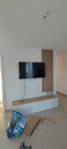 Photo de galerie - Pose de panneaux en bois 2 pièces sur le mur ainsi que la fixation tv au mur chez une cliente 