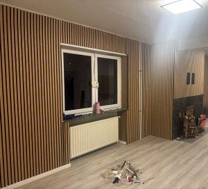 Photo de galerie - Habillage d’un mur et d’une cheminée en panneau de bois. 