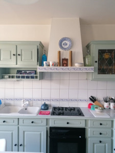 Photo de galerie - Meubles de cuisine couleur bois entièrement rénovés en couleur vert sauge avec boutons de portes plus ferrures peins en noir auparavant couleur doré 