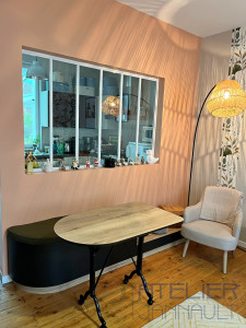 Photo de galerie - Banquette sur-mesure courbe avec assise confortable, associée à une table bois et métal esprit bistrot. L’ensemble crée un coin repas chaleureux, mis en valeur par une grande verrière intérieure.