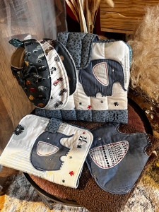 Photo de galerie - Coffret naissance contenant une cape de bain, un protège carnet de santé, 3 bavoirs et une pochette à couche et lingettes 