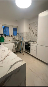 Photo de galerie - Cuisine plan et crédence marbre et finition en façade blanc brillant  