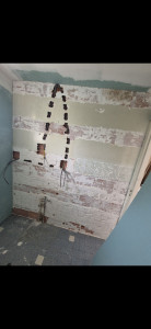 Photo de galerie - Passage de gaines et câbles pour futur prises de courant et sortie de câble miroir avant la pose de placo collé (ici pas d'ossature metallique pour un max de gain de place car pièce déjà très petite).