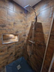 Photo de galerie - Douche façon italienne avec niche de rangement pour les produits de douche et barre de douche avec mitigeur thermostatique 