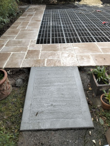 Photo de galerie - Dallage beige en opus avec petite rampe en béton balayé entourant un petit parking filtrant