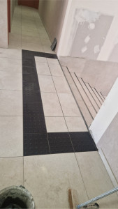 Photo de galerie - Entrée d’immeuble : Carrelage posé avec soin, bords parfaitement alignés et transition sol-escalier réalisée avec précision. Travail extrêmement professionnel