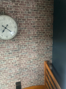 Photo de galerie - Réalisation d’une tapisserie effet brique sur un mur de mezzanine avec coupe difficile et sur mur de 5,30m de hauteur réaliser à l’aide d’un échafaudage et échelle. 