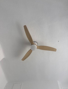 Photo de galerie - Installation d’un ventilateur au plafond dans une pièce, avec fixation sécurisée et branchement électrique propre