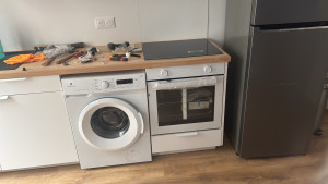 Photo de galerie - Installation complète d’électroménager en cuisine : lave-linge, four encastrable, plaque de cuisson et réfrigérateur. Raccordements soignés et mise en service effectuée.