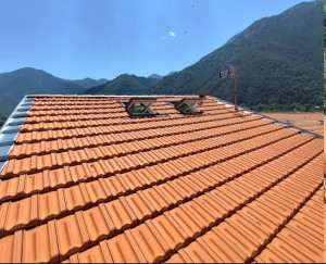 Photo de galerie - Après travaux, réalisation d'une couverture complète avec réfection totale de la charpente ainsi que de l'isolation, des rives, faîtage et des gouttières, près de 20 mètres de haut dans le village de Saint-Martin-Vésubie.