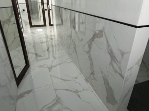 Photo de galerie - Couloir intérieur carrelé en grands carreaux imitation marbre, pose alignée avec joints fins pour plus d’élégance.