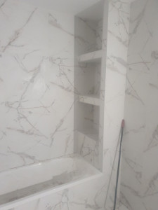 Photo de galerie - Pose de carrelage dans une salle de bain avec réalisation de niches murales. Finition soignée et précise.