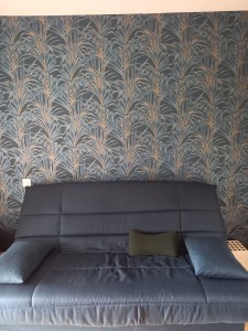 Photo de galerie - Pose d'un papier peint à  motifs et raccords sur le mur d'une chambre 