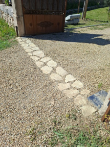 Photo de galerie - ​Allée de pas japonais, Cheminement composé de pierres plates disjointes posées sur un sol (ici du gravier) pour éviter que le petit chien ne creuse et s'en aille.
