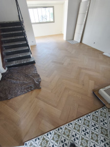 Photo de galerie - Pose parquet baton rompu Quickstep de chez Tanguy/Le Doré Caudan. pose particulière avec baguette de seuil et coupe escalier avec joint de finition pour un résultat impeccable 