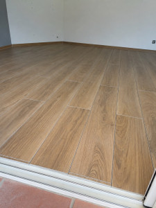 Photo de galerie - Pose de carrelage intérieur imitation bois, avec alignement soigné et finitions propres.