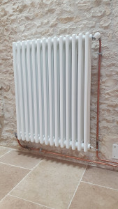 Photo de galerie - Pose d'un radiateur couplé sur une chaudière à granulés. Tuyauterie en cuivre avec raccords brasés